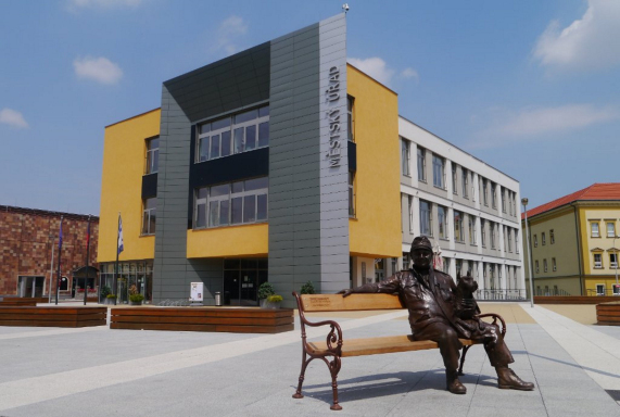 Budova nové radnice se sochou Švejka